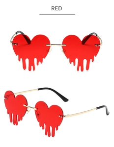 Détail de lunettes de soleil cœur sans monture rouges avec effet goutte et branches dorées