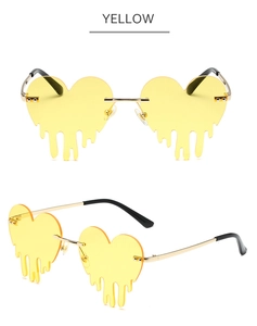 Détail de lunettes de soleil cœur jaunes avec verres effet goutte et monture dorée
