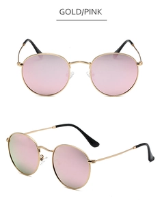 Detail of round gold metal frame sunglasses with reflective pink lenses and black tips