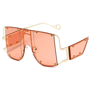 Futuristic oversized orange sunglasses with gold frame and decorative metal rivets