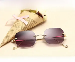 Détail de lunettes sans monture avec verres dégradés violets et monture en métal doré