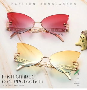 Detail of butterfly shaped rimless sunglasses with gold metal frame and gradient lenses