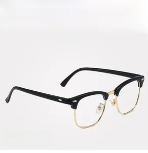 Detail of Clubmaster style glasses featuring black browline frame and gold metal accents