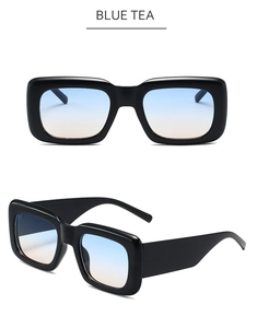 Detail view of square sunglasses with thick black frames and blue tea gradient lenses
