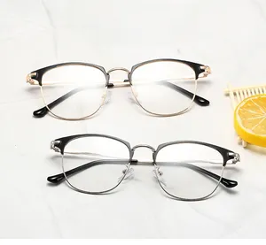 Detail of half-frame eyeglasses frames in black-gold and black-silver on marble background