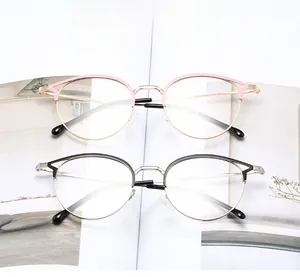 Détail de montures de lunettes œil de chat en métal, coloris noir doré et or rose