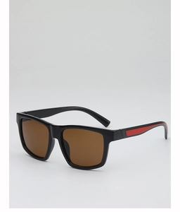 Detail view of square black sunglasses with brown lenses and red stripe on the temple
