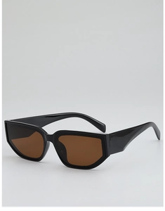 Détail de lunettes de soleil œil-de-chat géométriques avec monture noire et verres ambrés