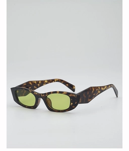 Détail de lunettes de soleil à monture écaille épaisse et verres vert lime translucides