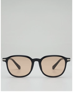 Détail de lunettes de soleil noires avec verres ambrés et ornements en métal argenté