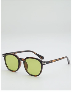 Détail de lunettes de soleil rondes en écaille avec verres jaune-vert et accents en métal
