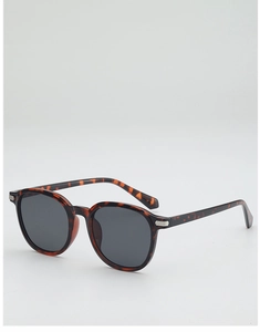 Détail de lunettes de soleil rondes écaillées avec accents argentés et verres gris