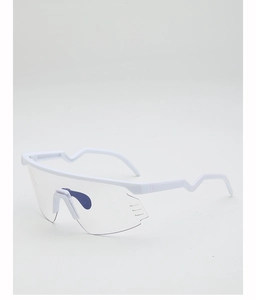 Close-up of white sports goggles showing transparent lens and non-slip wavy temples