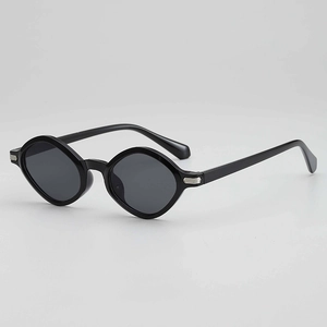 Polished black irregular polygon sunglasses with silver metal accents on grey background