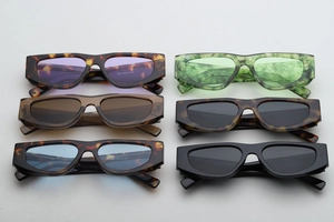 Flat lay of small rectangular sunglasses in tortoise shell and vibrant dopamine colors