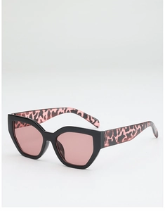 Close-up of cat-eye sunglasses featuring pink leopard pattern and tinted lenses
