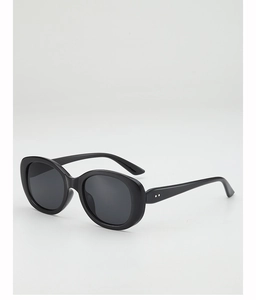 Détail de lunettes de soleil ovales rétro avec monture noire épaisse et points argentés