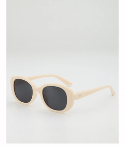 Détail de lunettes de soleil ovales crème avec verres noirs et charnières à rivets