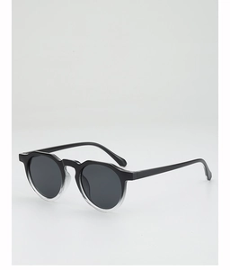 Detail of round sunglasses featuring retro gradient black to clear frames and grey lenses
