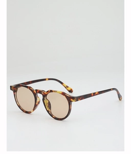 Detail view of round tortoiseshell sunglasses frame with gradient amber lenses