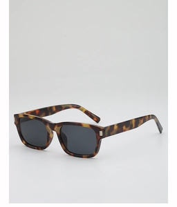 Close-up of tortoise shell square sunglasses frame with metallic accents and dark lenses