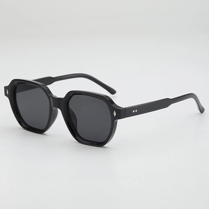 Occhiali da sole poligonali color gelatina con montatura nera oversize e rivetti argento