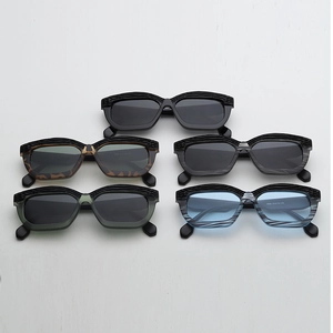 Detail of five irregular thick-frame sunglasses showing striped textures on top edges