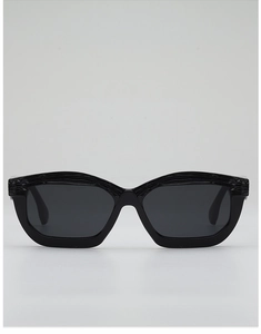 Detail of black sunglasses featuring horizontal textured stripes on the upper frame edge