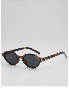 Close-up of tortoise shell frame texture and silver hinge detail on oval sunglasses