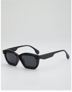 Detail shot of black sunglasses featuring a unique 3D rock texture on the upper frame