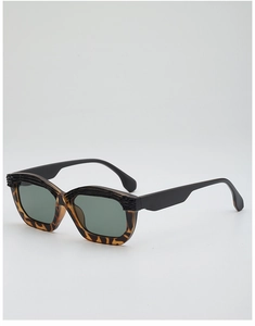 Close-up of tortoise shell sunglasses featuring black wood grain texture on the upper frame