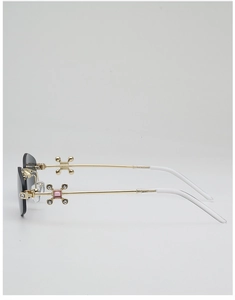 Détail des branches en métal doré avec croix sertie de diamants sur lunettes sans monture