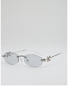 Détail de lunettes de soleil polygonales sans monture avec fleur en strass sur métal argent