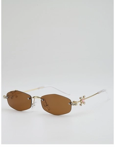 Détail de lunettes de soleil polygonales sans monture avec verres bruns et strass