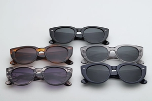 Flat lay of retro oversized sunglasses in black, tortoiseshell, and transparent colors