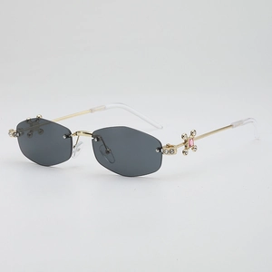 Lunettes de soleil hexagonales sans monture avec monture dorée et strass roses