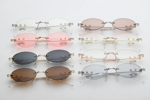 Detailed view of eight rimless oval sunglasses with crystal studs and metal temples