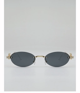 Detailed view of oval rimless sunglasses featuring rhinestone hinges and golden metal arms