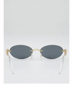 Detail of oval rimless sunglasses with grey lenses and gold metal bridge