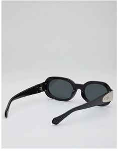 Détail de lunettes de soleil ovales noires avec charnière métallique CD argentée sur la branche