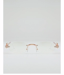 Detailed close-up of oval lenses with rose gold metal bridge and rhinestone cross hinges