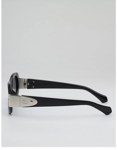 Détail des lunettes de soleil ovales noires avec logo CD argenté incrusté sur la branche