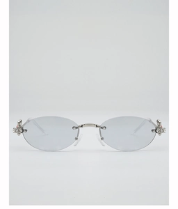 Detail of rimless oval sunglasses featuring silver metal bridge and butterfly crystal accents