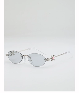 Detailed view of silver cross hinge with pink gemstone on oval rimless sunglasses