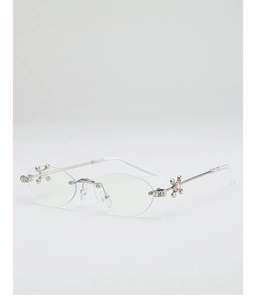 Detail of silver oval rimless sunglasses with cross floral hinge and pink gemstone