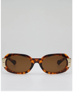 Détail de lunettes de soleil ovales en écaille avec des accents en métal doré élégants