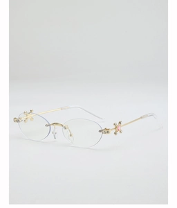 Close-up of rimless sunglasses featuring gold metal star-shaped decor and pink gemstone