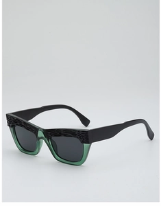 Detail of retro cat-eye sunglasses featuring black embossed texture and green frame