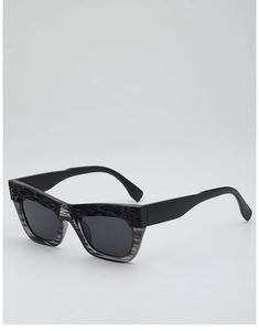 Detail of retro cat-eye sunglasses featuring textured upper frame and translucent lower lens rims