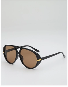 Detail of pilot sunglasses showing black frame with gold bridge accent and brown lenses